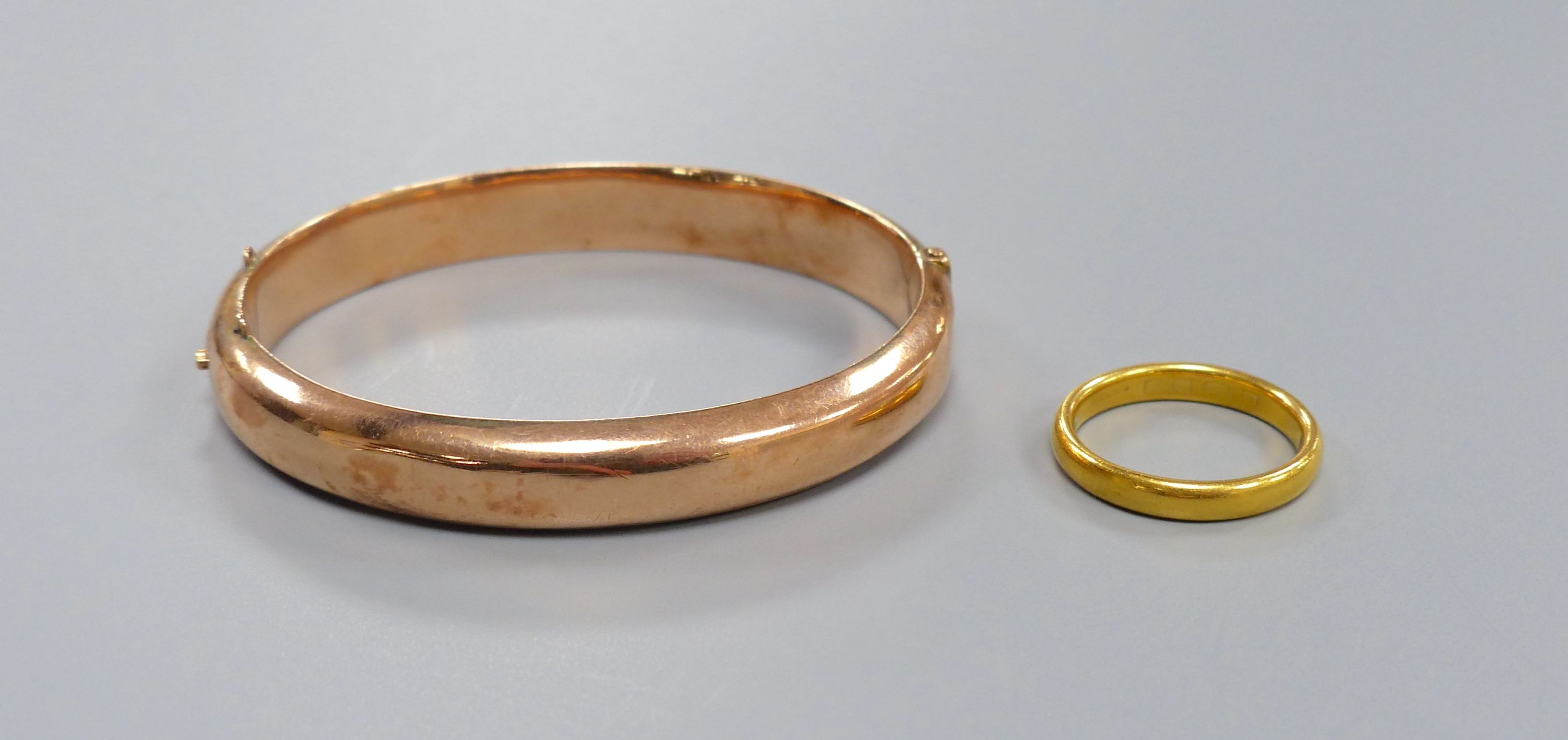 An 18ct gold wedding band, 6.1 grams and a 9ct gold hinged bangle, 12.3 grams.